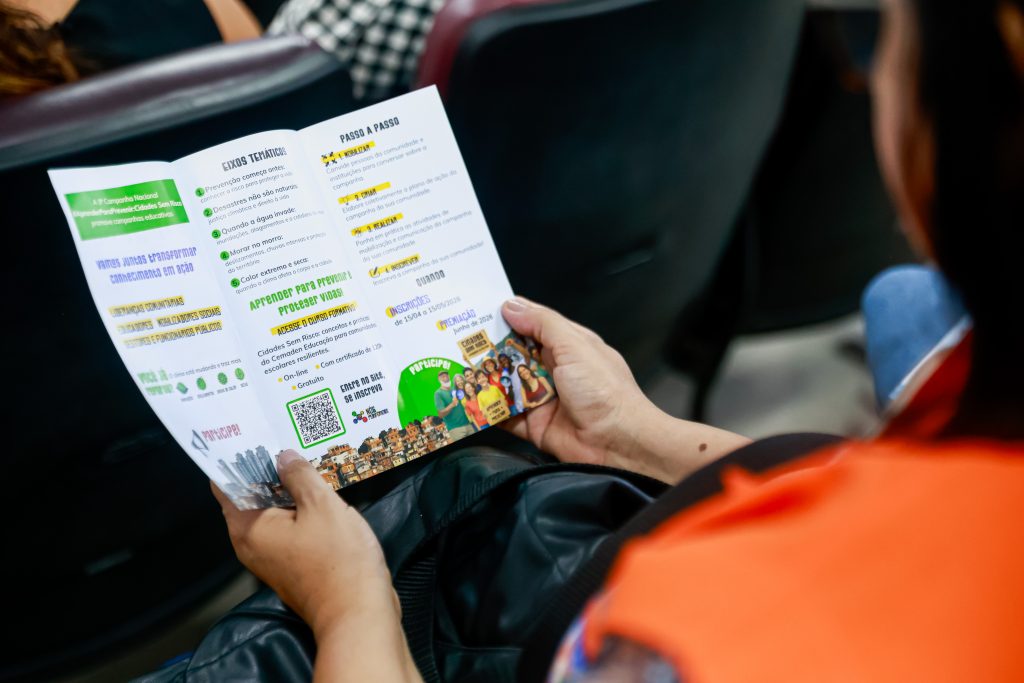 defesa civil lendo folheto da Campanha #AprenderParaPrevenir
