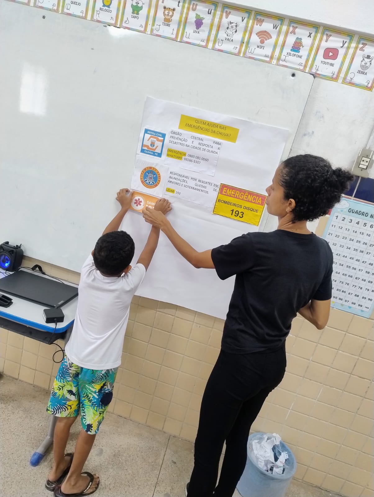 Professora e aluno em plena produção de cartaz