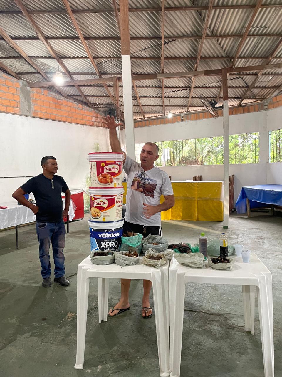 Colaborador José Pompeu realizando demonstração prática de compostagem na oficina comunitária, em maio de 2026.