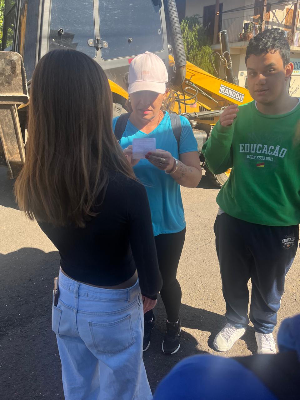alunos participantes da campanha distribuindo os folders para moradores da comunidade