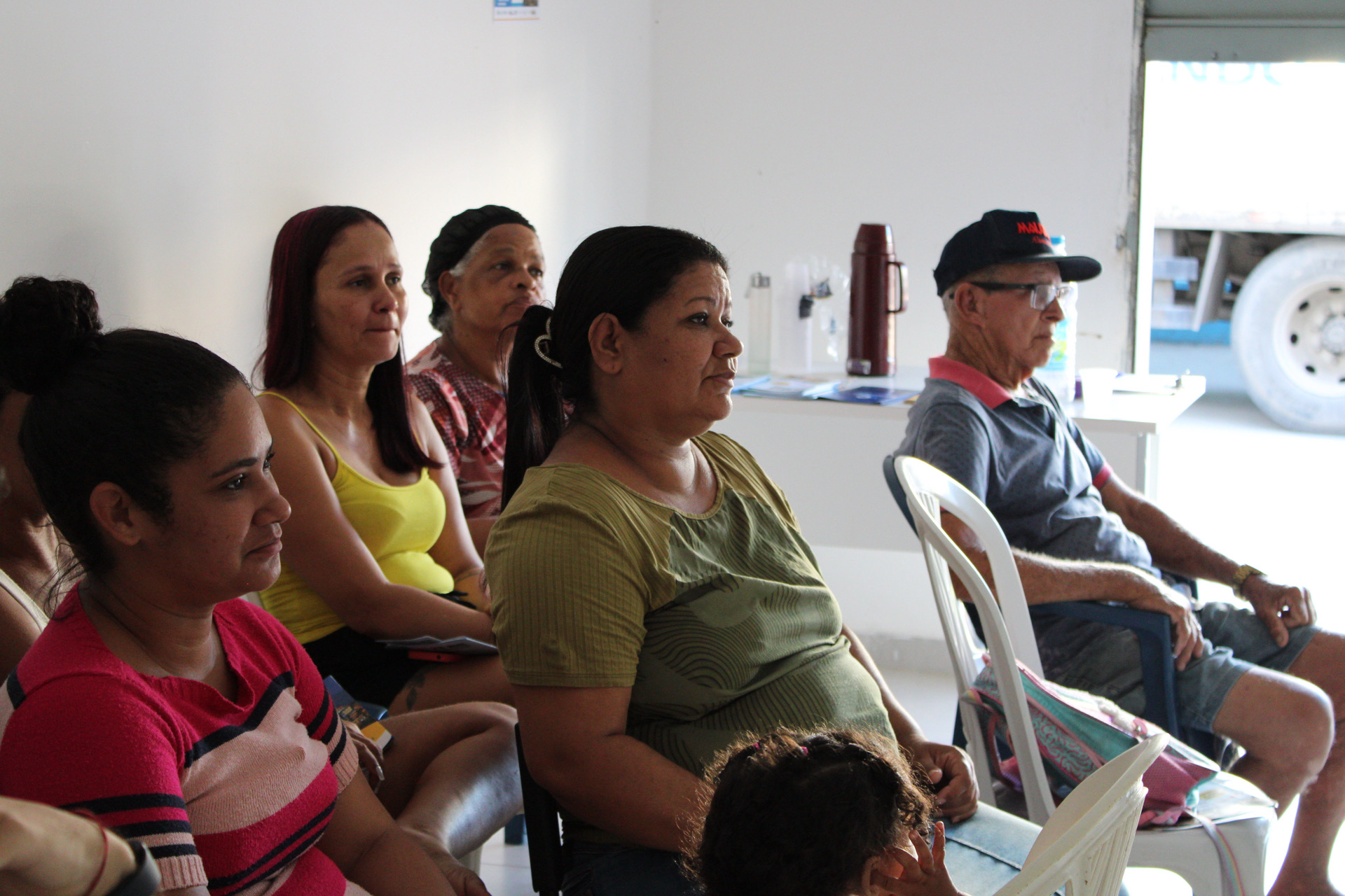 A imagem evidencia a diversidade dos participantes presentes na atividade comunitária, com destaque para a forte presença de mulheres e pessoas idosas.