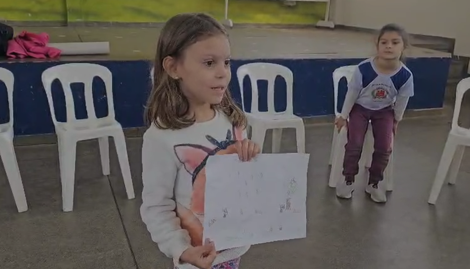 Alice (5 anos) mostrando sua proposta para diminuir as enchentes no bairro, pois o lixo entope os bueiros.